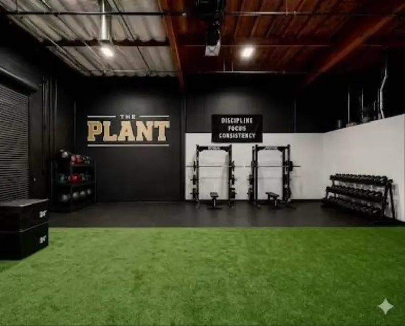 The strength training area with racks, dumbbells and open turf for speed work.